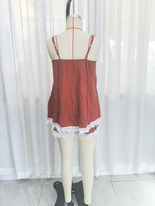 Detailed view of brick red camisole and shorts set with delicate white fringe lace trim