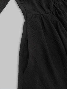 Detail of black shirt dress featuring textured fabric, side pocket and invisible zipper