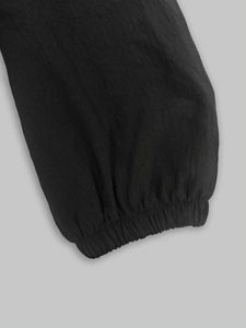 Detailed macro view of black textured fabric and elastic cuff on French style midi dress