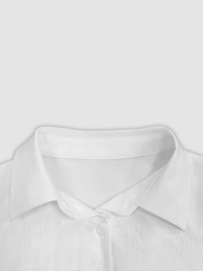 Detail of elegant white shirt collar with sharp points and a clean button closure