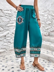 Dettaglio della stampa etnica 3D e delle tasche sui pantaloni larghi boho verde petrolio