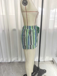 Détail du short de plage à rayures verticales colorées avec cordon de serrage et poches latérales