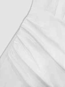 Detail shot of white elegant dress showing refined side pleats and ruched fabric texture
