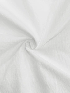 Close-up of white pleated cotton fabric texture showing soft elegant spiral draping