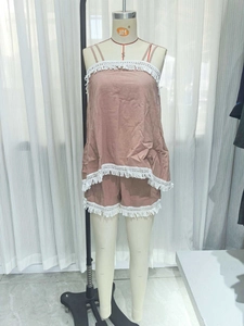 Detail of dusty pink camisole set featuring white tassel lace trim and cotton linen texture