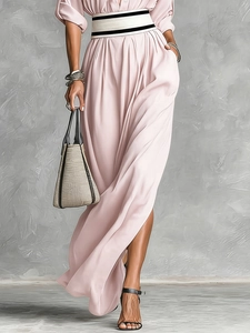 Detail of light pink draped maxi dress with a bold contrast belt and side pocket detail