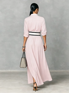 Detail of light pink long sleeve dress featuring an elegant shirt collar and striped belt