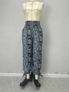 Detail view of smocked high waist and bohemian floral print on flowy summer trousers