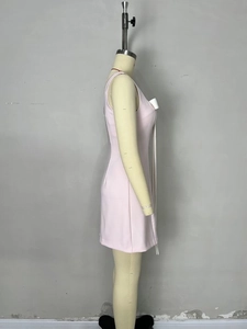 Slim fit light pink sleeveless mini dress with white bow detail on a mannequin