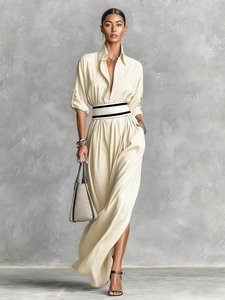 Detail of elegant cream maxi dress with draped silk texture and contrast waist belt