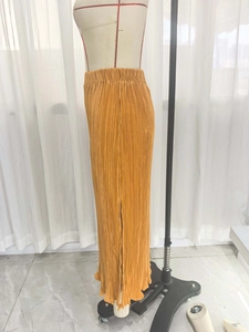 Detailansicht eines senfgelben Faltenrocks mit hoher Taille und seitlichem Schlitz