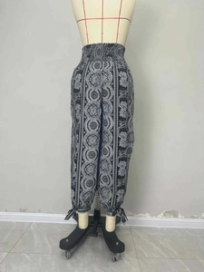 Detail of bohemian black high waisted floral trousers with pleated elastic smocked waist