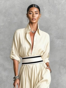 Detail of elegant cream dress with turn-down collar and striped waist belt accent