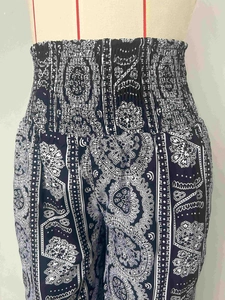 Navy blue high-waisted bohemian pants with smocked waist and white floral paisley prints
