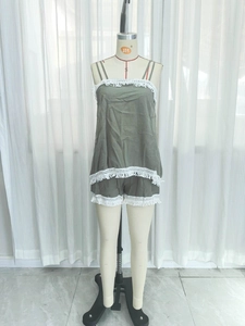 Detail of green two-piece set featuring white lace tassel trim on hem and shorts