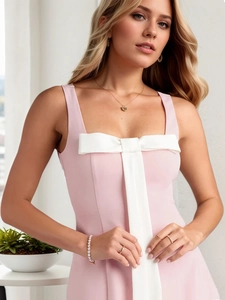 Close-up of pink slim fit dress featuring a large decorative white bow on the chest