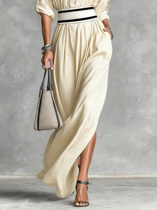 Detail of cream long dress with striped elastic waist belt and high side slit