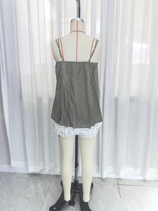 Detail view of army green camisole with white lace trim and fringe hem design