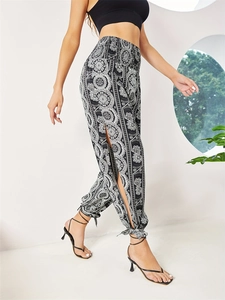 Detail of high waist floral print trousers with side slits and ankle ties in boho style