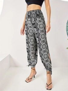 Detail of high waist floral mandala pants with side slits and ankle tie-up design