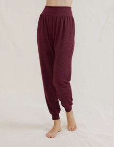 Detail of high-waisted burgundy yoga joggers with ribbed cuffs and elastic waistband