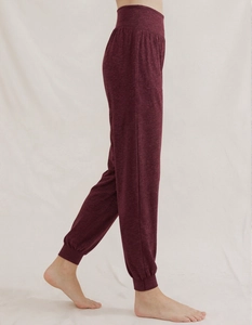 Macro view of burgundy high-waisted yoga pants showing the knit texture and ribbed cuffs