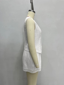 Nahaufnahme der geometrischen Spitzen-Details am weißen ärmellosen Weste und Shorts Set