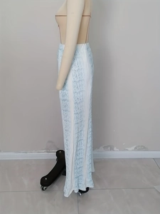 Macro detail of high-waist wide-leg pants featuring vertical pleats and blue floral print
