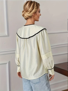 Chemisier élégant en satin beige à col V avec bordure noire et manches plissées