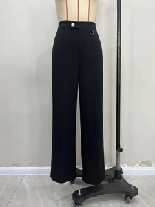 Elegant black high-waisted wide-leg trousers with gold button and metal ring details