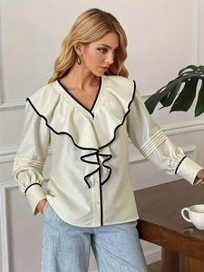 Blouse française crème à col en V avec bordures ondulées noires et volants élégants