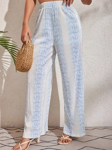 Detail of high waisted pleated wide leg trousers with blue abstract print and fluid drape