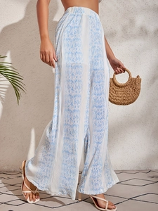 Detailed macro view of the pleated fabric texture and blue print on high waist trousers