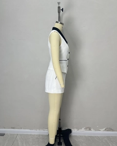 Detail of white two-piece set with black contrast lapel and vest button accents