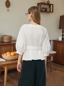 Elegante camicetta bianca con scollo a barchetta, cintura e maniche a sbuffo per uno stile chic