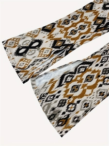 Detailweergave van de uitlopende zoom met Azteekse print en zijsplit op de gebreide broek