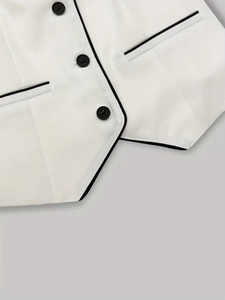 Detail of white textured vest featuring black contrast piping and three dark buttons