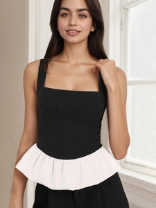 Dettaglio del top peplum in contrasto bianco e nero con scollo quadrato e senza maniche