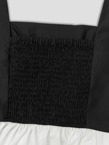 Dettaglio della tecnica smocking e del contrasto bianco e nero sulla canotta vintage