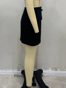 Detailed side view of black mini skirt featuring stylish metal buckle on waistline