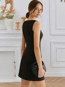 Elegante mini abito nero senza maniche con fibbia anteriore e vita stretta in un interno