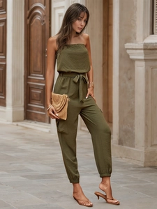 Detail of army green tube jumpsuit showing pleated fabric texture and cargo pocket