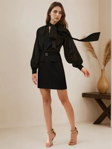 Detail view of high-waist A-line skirt with metallic buckle and elegant bow-tie chiffon blouse