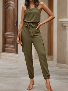Detail of olive green strapless jumpsuit showing crinkled texture fabric and tie-up belt