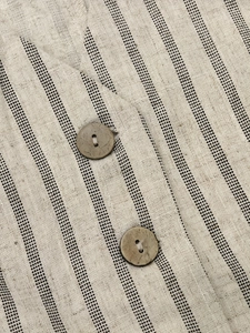 Close-up of linen fabric with vertical stripes and vintage buttons on a vest