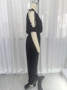 Detail view of black woven jumpsuit featuring cold shoulder design and ruffled sleeves