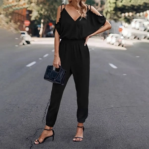 Detail of black cold-shoulder jumpsuit featuring elastic waist and cinched leg cuffs