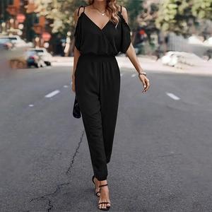 Outdoor street shot of a black off-shoulder jumpsuit with V-neck and elastic waist