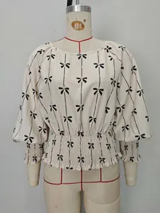 Blouse à fleurs à manches longues avec taille froncée et motifs nœuds noirs sur crème