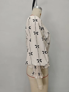 Détail de l'ourlet smocké et des poignets élastiques sur une blouse beige fleurie